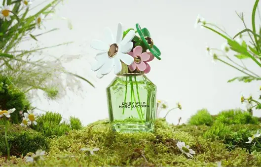 Marc Jacobs Daisy Wild fragrance bottle on mossy garden bed